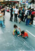 There was a streetmarket, the busy road was closed to traffic, the these kids decided to  draw on the usually busy  street.